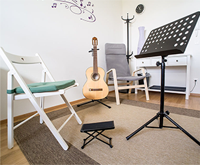Guitar, music stand and chair in classroom